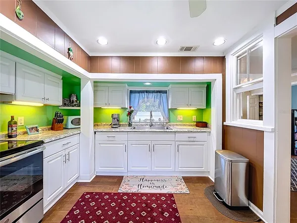 a kitchen with stainless steel appliances granite countertop a stove a sink and a microwave