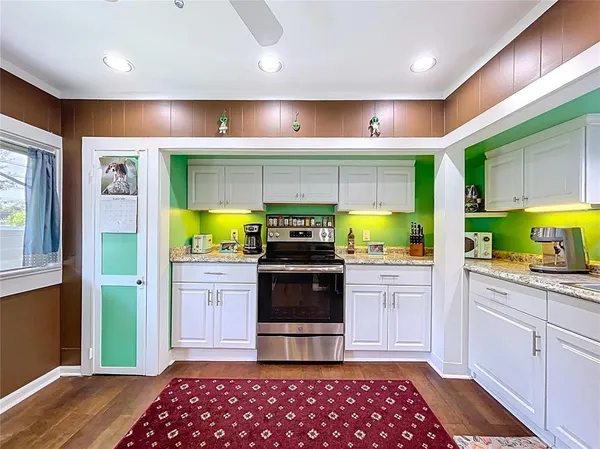 a kitchen with stainless steel appliances kitchen island granite countertop a stove and cabinets