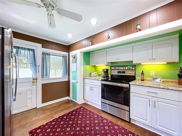 a living room with stainless steel appliances granite countertop furniture a fireplace and a window