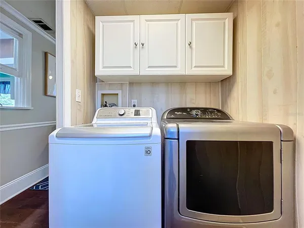 a view of a hallway with wooden floor and dining room view
