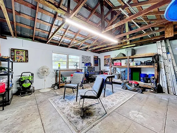 a view of a backyard with couches plants and large tree