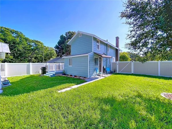 an aerial view of residential houses with outdoor space and trees