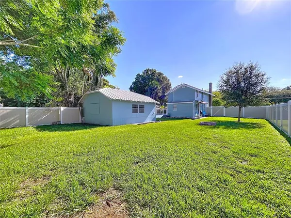an aerial view of a house with a yard and lake view