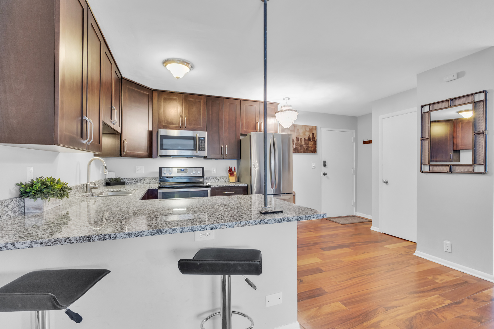 320 Circle Avenue, Unit 404 Forest Park, IL 60130 - Photo 2 of 16 a kitchen with stainless steel appliances granite countertop a sink a stove a refrigerator cabinets and chairs