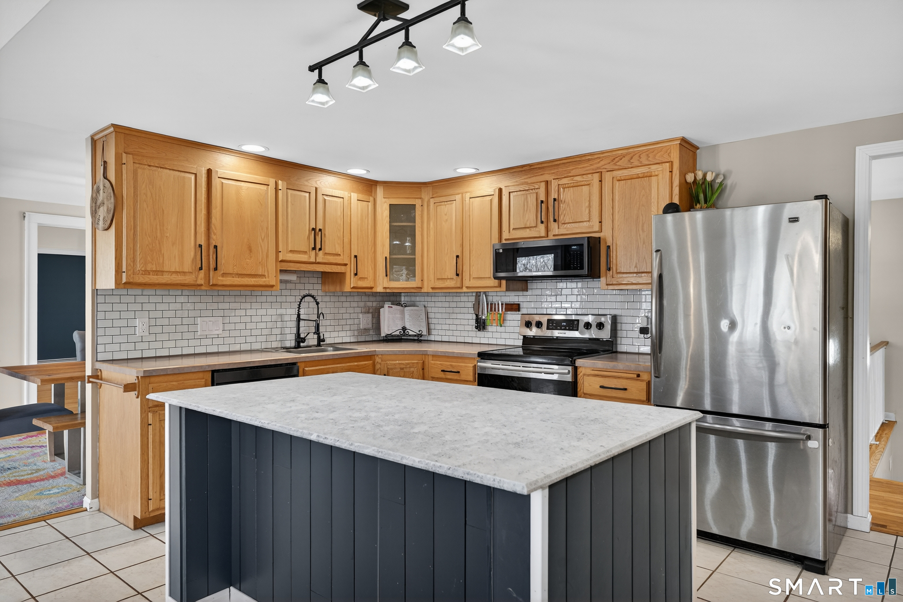 18 Riverside Terrace Madison, CT 06443 - Photo 12 of 40 a kitchen with granite countertop a refrigerator a sink a stove a microwave and island