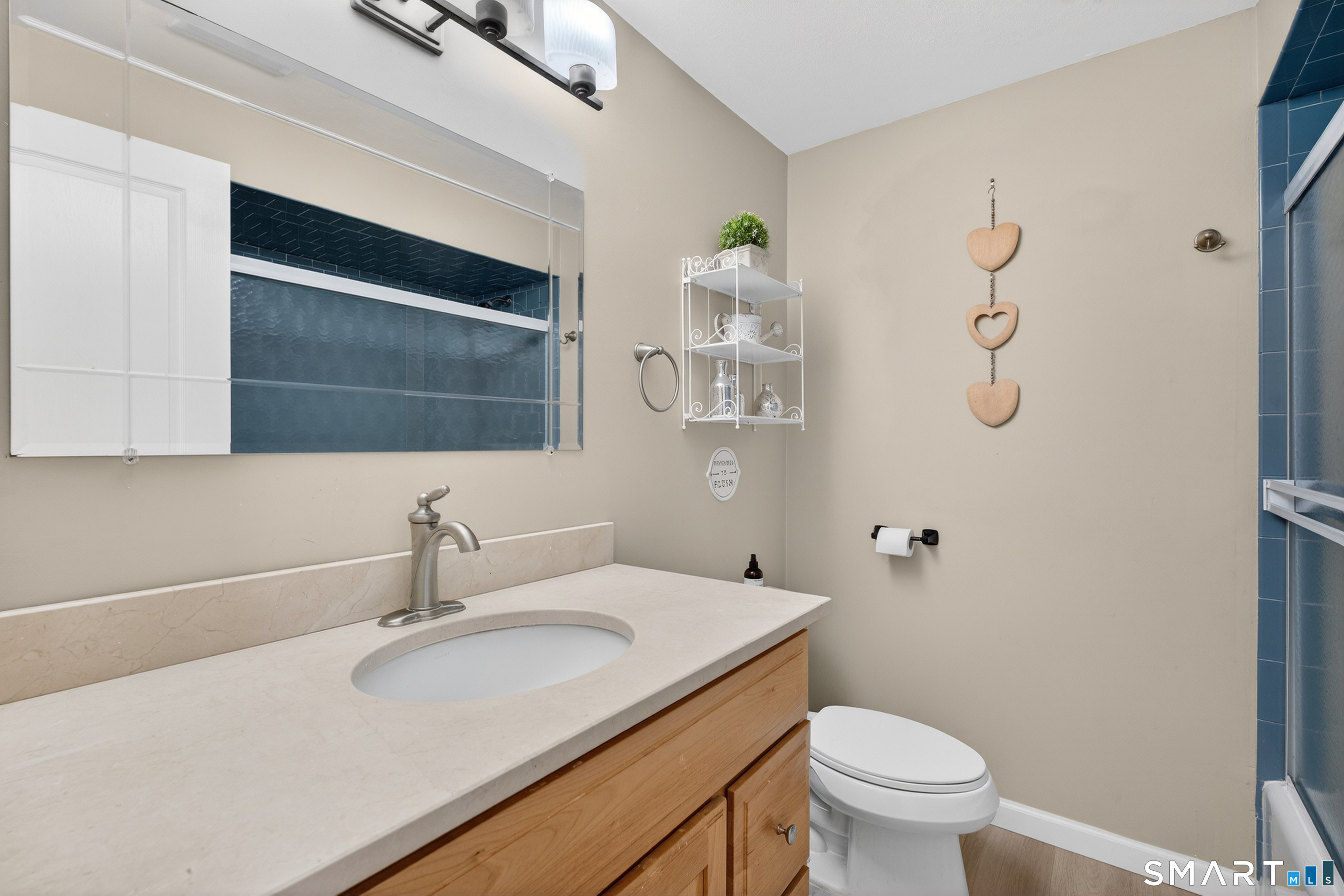 18 Riverside Terrace Madison, CT 06443 - Photo 19 of 40 a bathroom with a granite countertop sink a toilet and a mirror