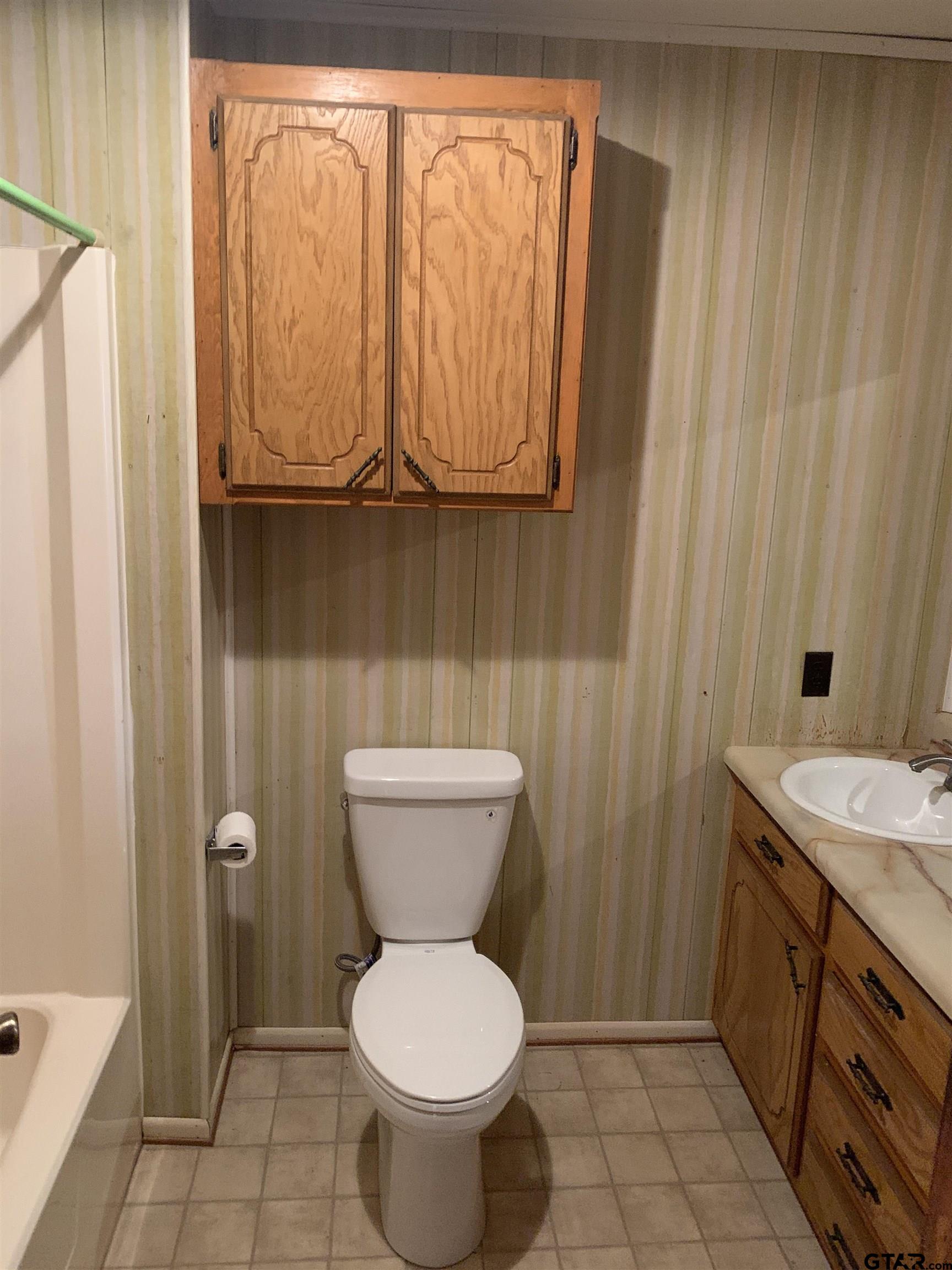 304 6th Street Southwest Bogata, TX 75417 - Photo 14 of 30 a bathroom with a toilet a sink and a shower curtain