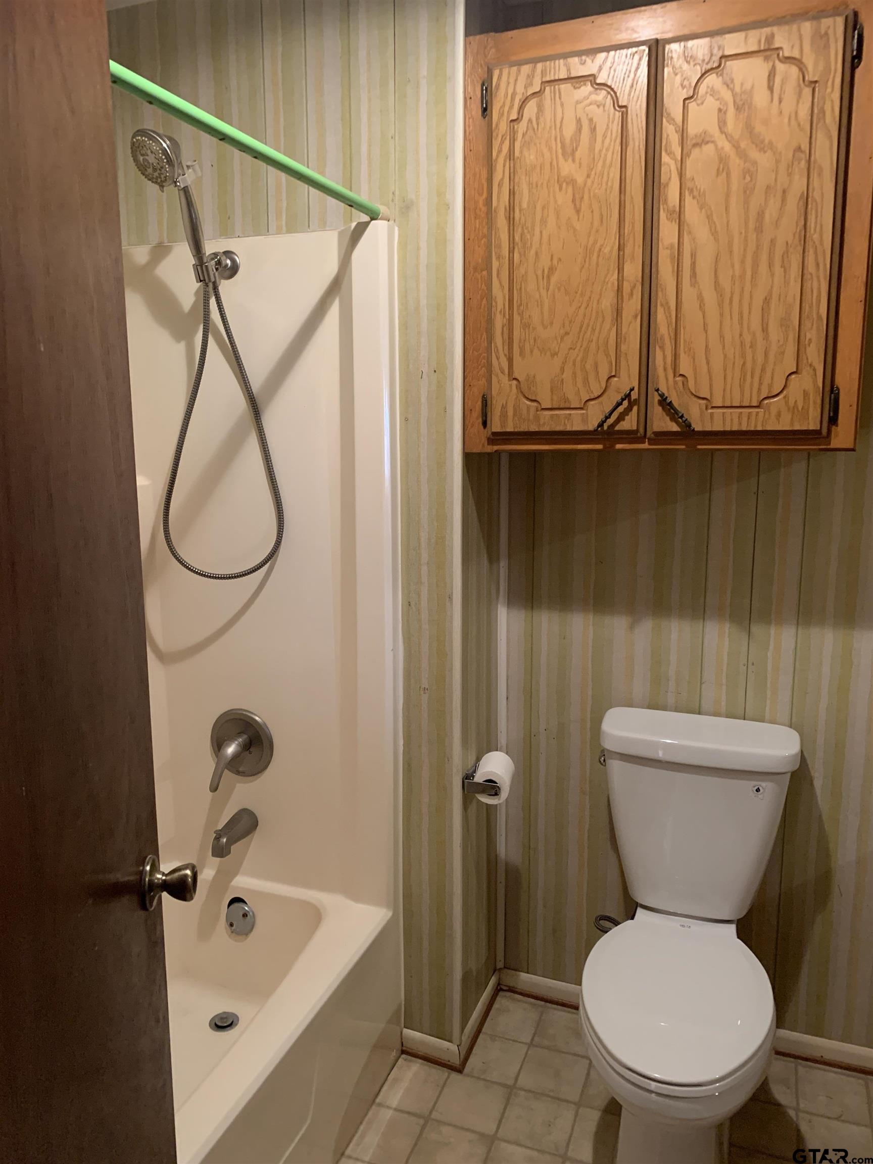 304 6th Street Southwest Bogata, TX 75417 - Photo 15 of 30 a white toilet sitting next to a bathroom sink and tub
