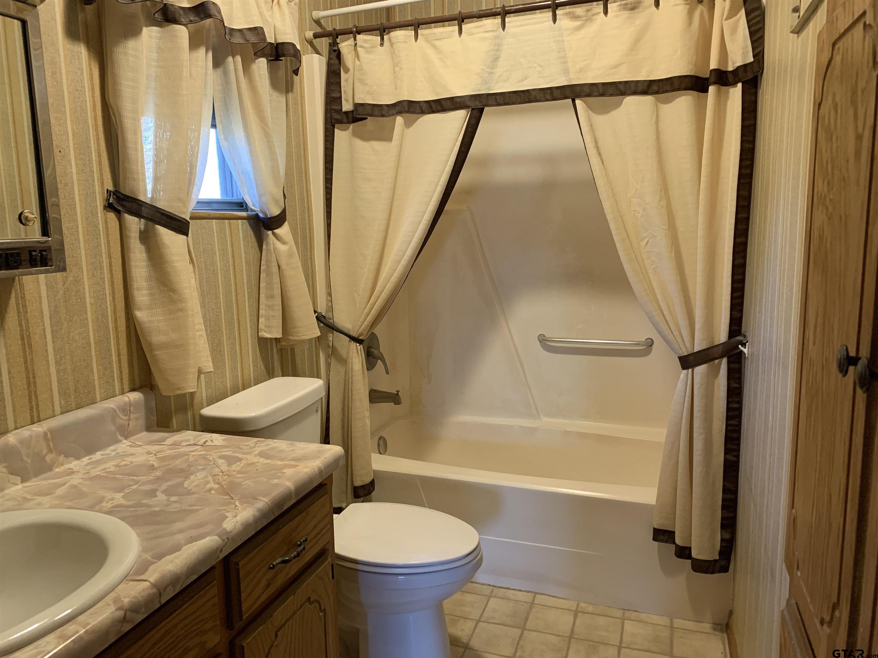 304 6th Street Southwest Bogata, TX 75417 - Photo 21 of 30 a bathroom with a granite countertop sink toilet and shower