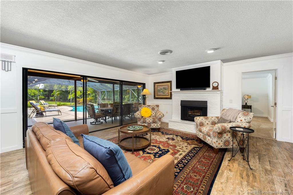 4 Ridgeview Road North Stuart, FL 34996 - Photo 16 of 57 a living room with furniture a fireplace and a flat screen tv