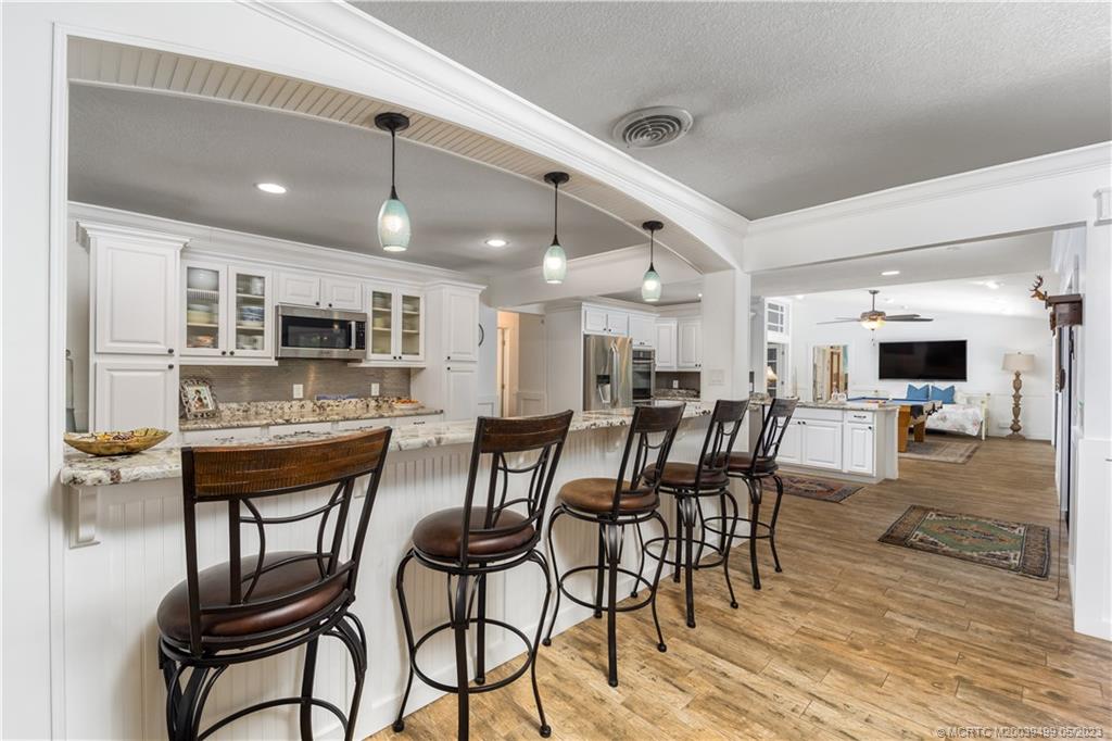 4 Ridgeview Road North Stuart, FL 34996 - Photo 21 of 57 a dining area with stainless steel appliances kitchen island granite countertop a dining table chairs and granite counter top