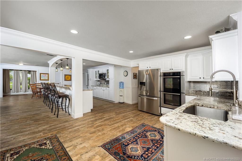 4 Ridgeview Road North Stuart, FL 34996 - Photo 23 of 57 a kitchen with stainless steel appliances kitchen island granite countertop a refrigerator and a sink
