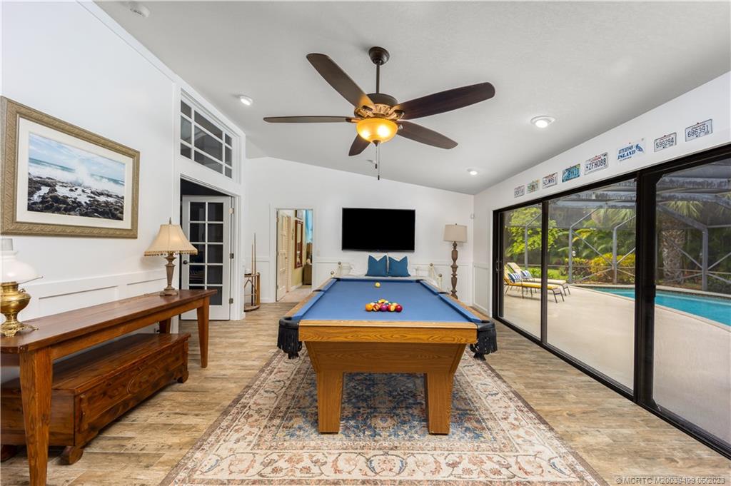 4 Ridgeview Road North Stuart, FL 34996 - Photo 24 of 57 a living room with furniture a flat screen tv and a floor to ceiling window