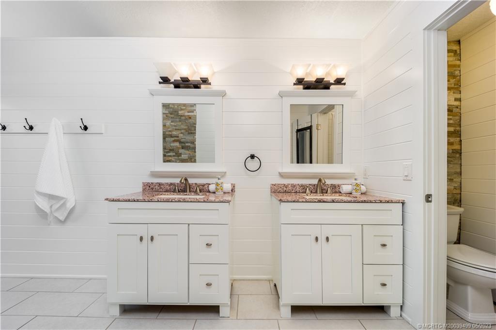 4 Ridgeview Road North Stuart, FL 34996 - Photo 31 of 57 a bathroom with a double vanity sink a mirror and a toilet