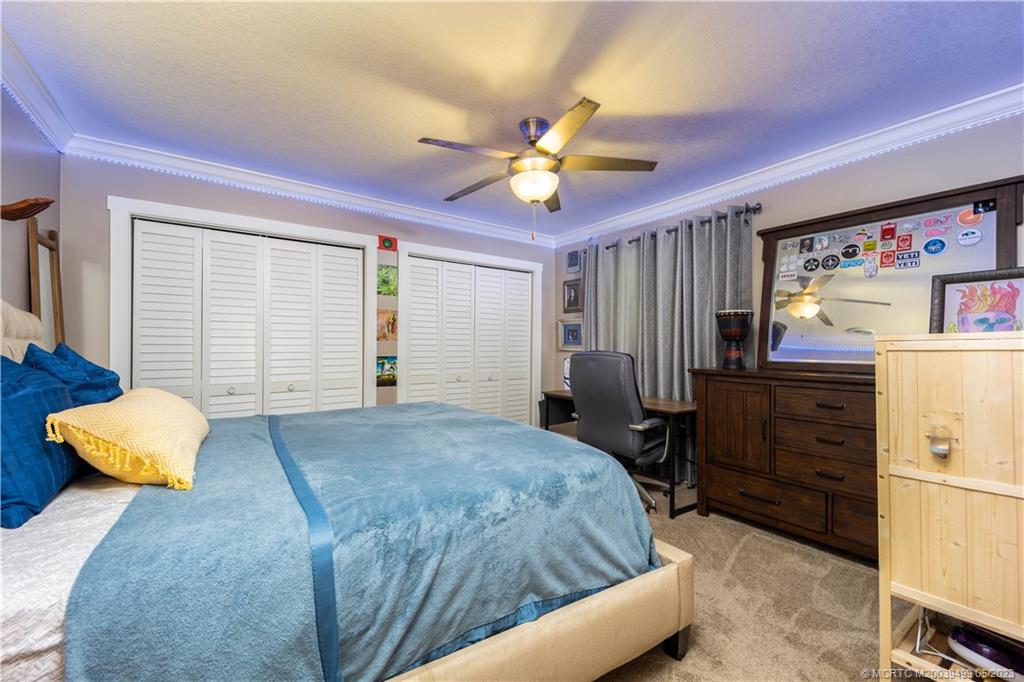 4 Ridgeview Road North Stuart, FL 34996 - Photo 37 of 57 a bedroom with a bed and a chandelier