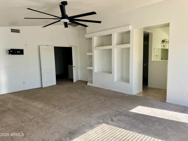 a view of a big room with closet and a ceiling fan