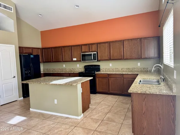 a kitchen with a sink a stove top oven and refrigerator