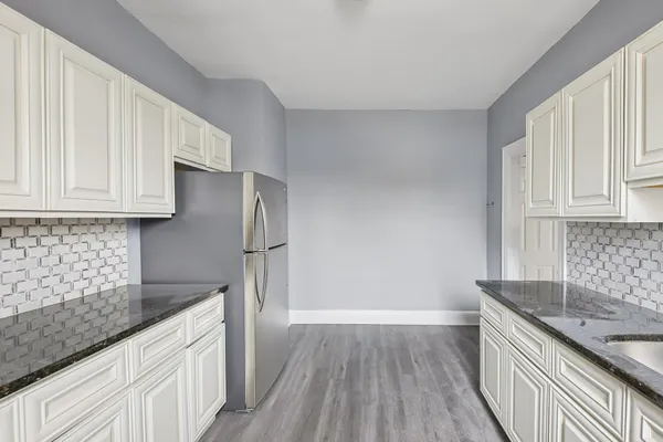 a kitchen with granite countertop a sink stove and cabinets