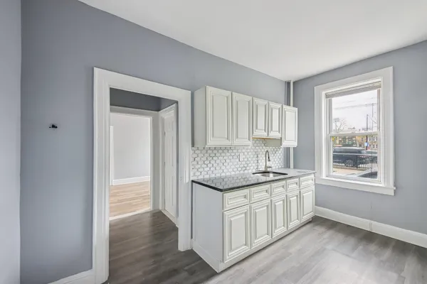 a kitchen with stainless steel appliances granite countertop a sink and a granite counter tops with wooden floors