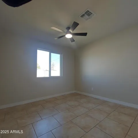 a view of an empty room and a ceiling fan