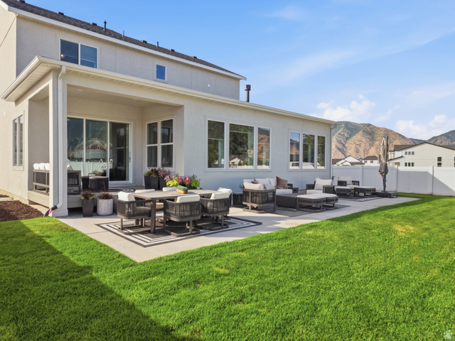 2559 West Aurora Avenue Mapleton, UT 84664 - Photo 57 of 60 Expansive backyard featuring a large concrete patio with a covered section, mature green lawn, and mountain scenery