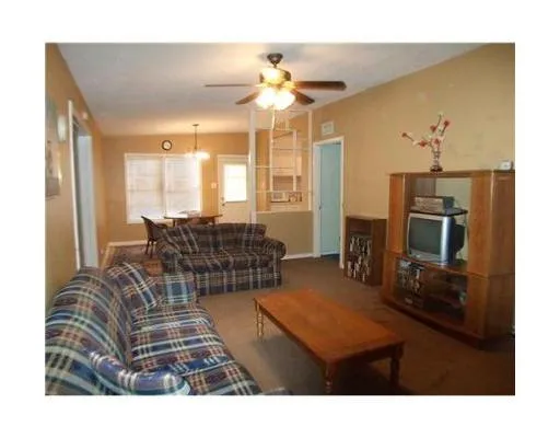 a living room with furniture a chandelier and a flat screen tv