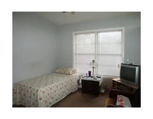 a bedroom with a bed window and cabinet