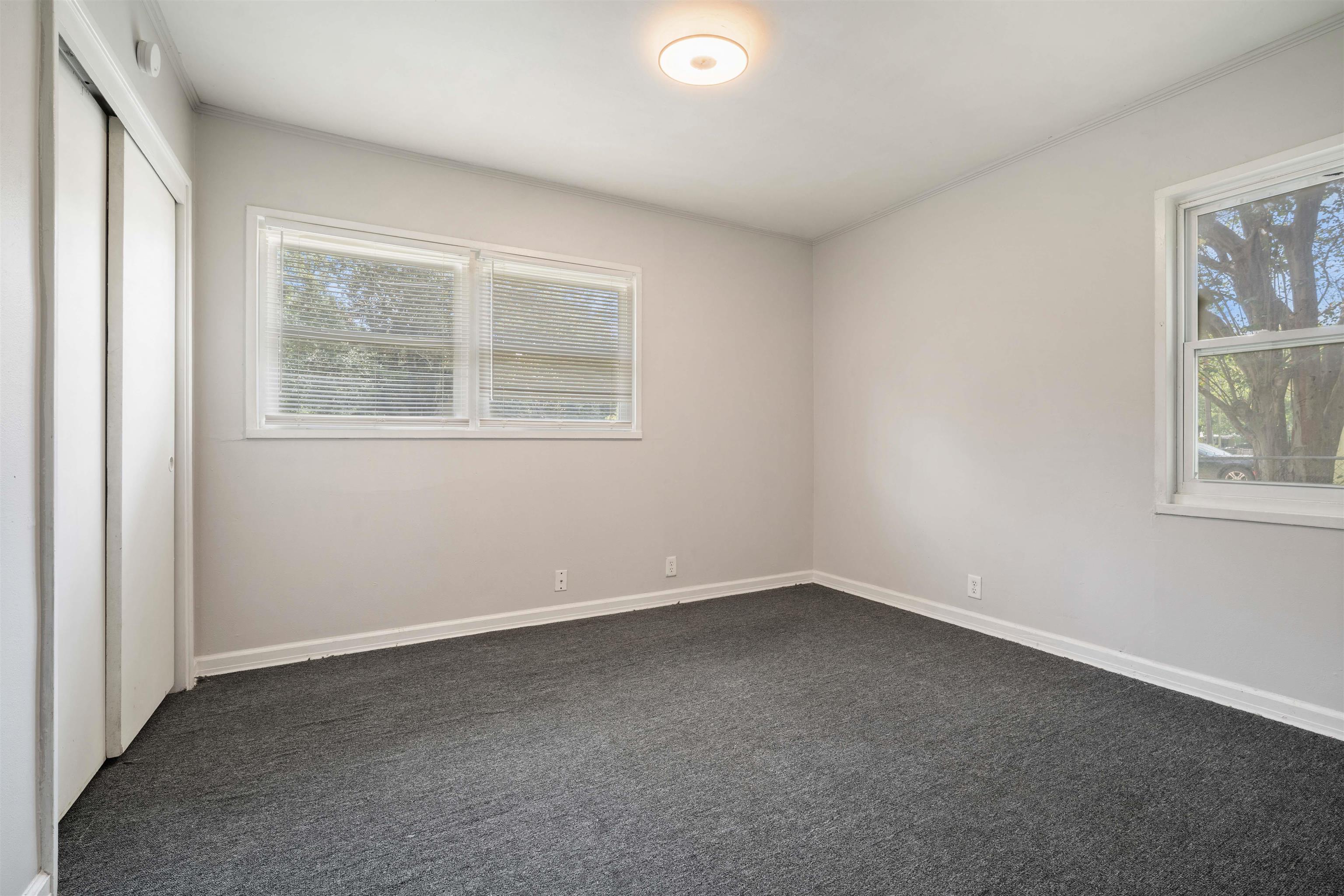 3014 Farcott Street Mobile, AL 36606 - Photo 17 of 26 Unfurnished bedroom with a closet, dark colored carpet, multiple windows, and crown molding