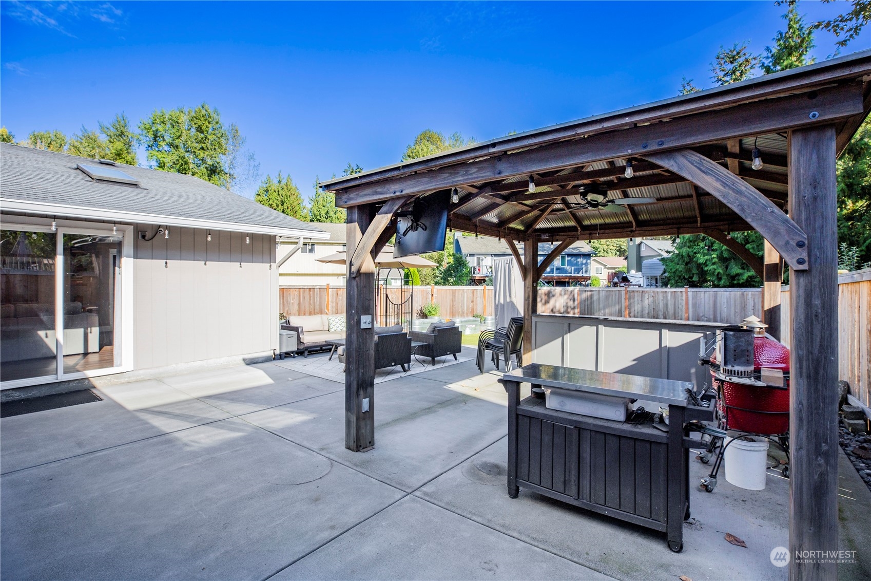 1826 225th Street Southeast Bothell, WA 98021 - Photo 29 of 33 a view of a patio with table and chairs under an umbrella with a small yard