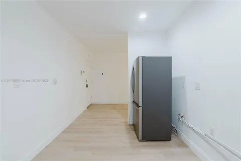 an empty room with wooden floor and entrance