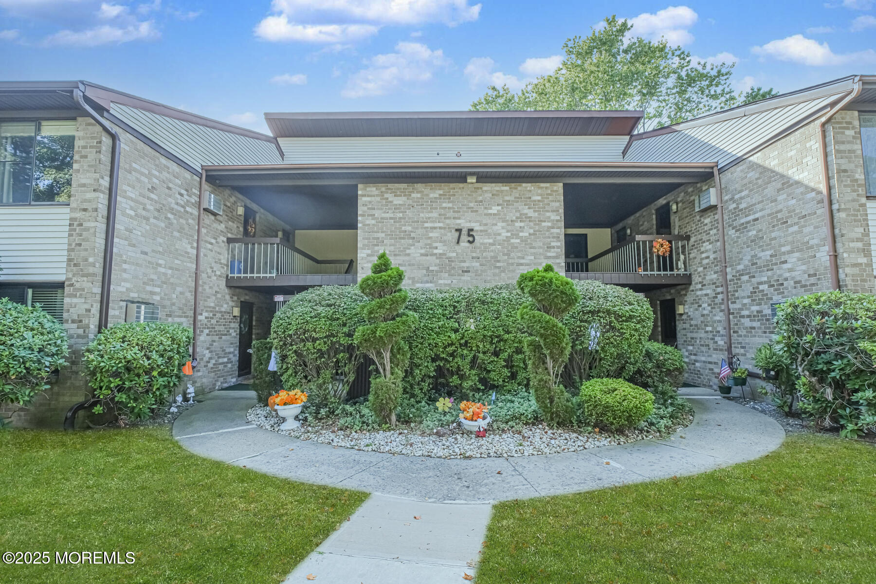 75 Overlook Way, Unit K Manalapan, NJ 07726 - Photo 2 of 24 a front view of a house with a yard and potted plants