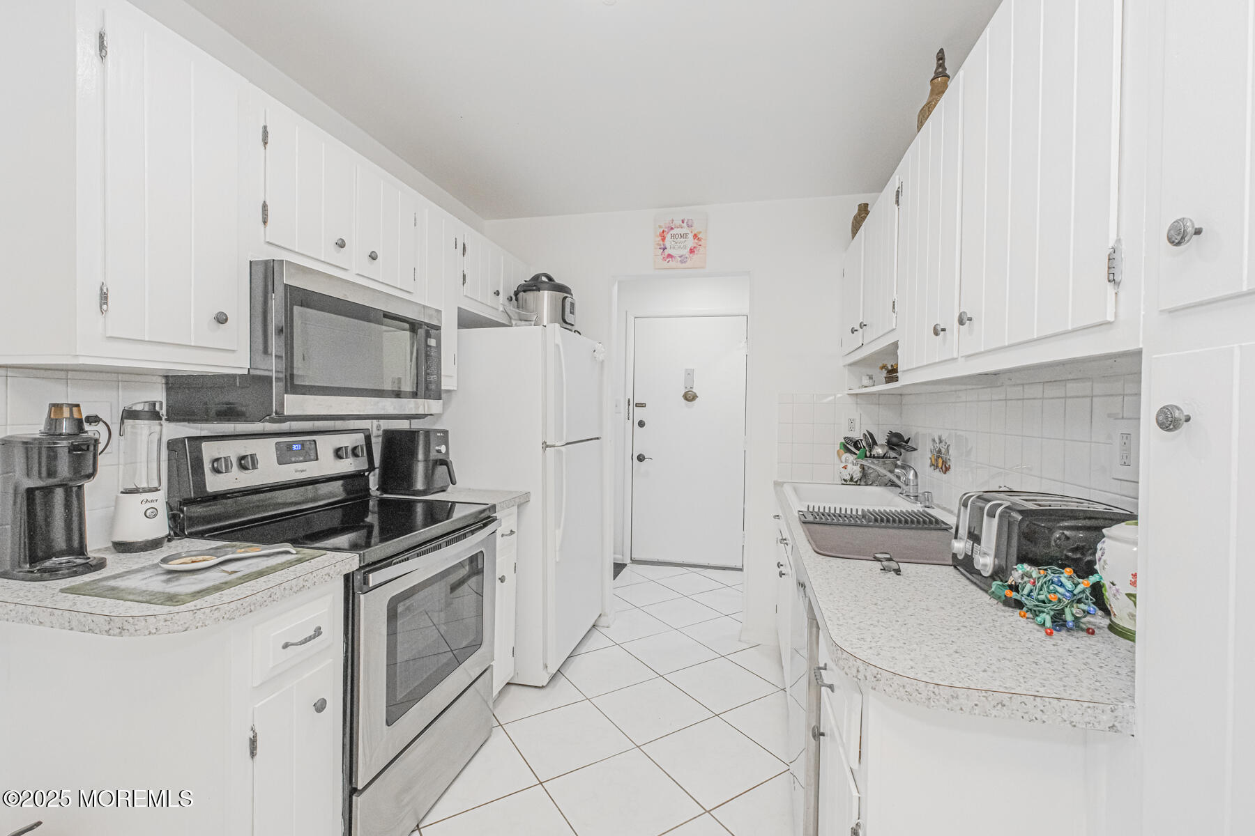 75 Overlook Way, Unit K Manalapan, NJ 07726 - Photo 8 of 24 a kitchen with stainless steel appliances white cabinets and a refrigerator
