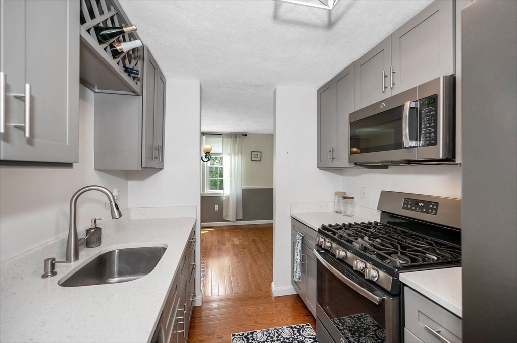 31 Patrick Road, Unit 31 Tewksbury, MA 01876 - Photo 12 of 40 a kitchen with stainless steel appliances granite countertop a sink stove and microwave