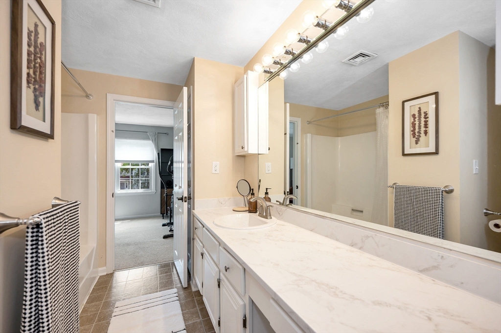 31 Patrick Road, Unit 31 Tewksbury, MA 01876 - Photo 30 of 40 a bathroom with a sink a mirror and a shower