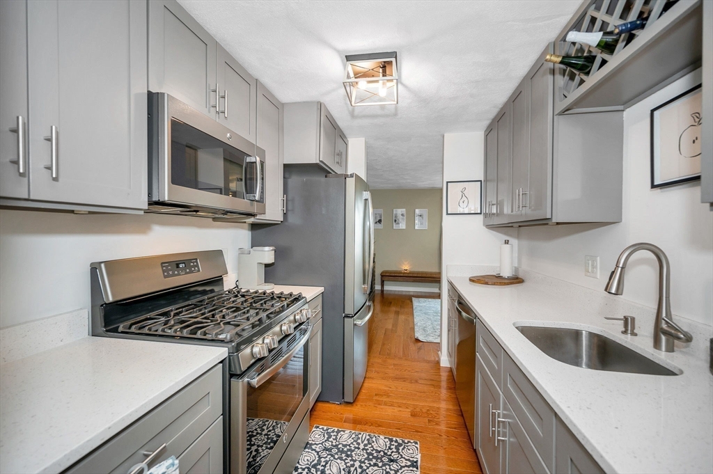 31 Patrick Road, Unit 31 Tewksbury, MA 01876 - Photo 10 of 40 a kitchen with stainless steel appliances granite countertop a sink stove and refrigerator