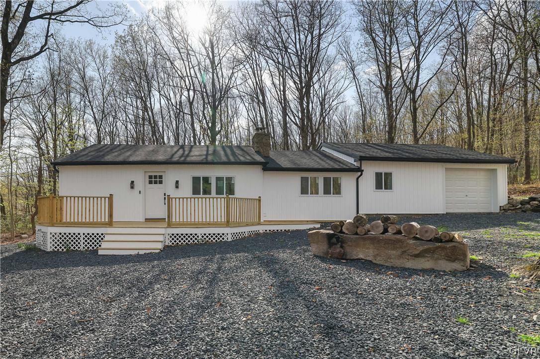 a view of a house with backyard and trees
