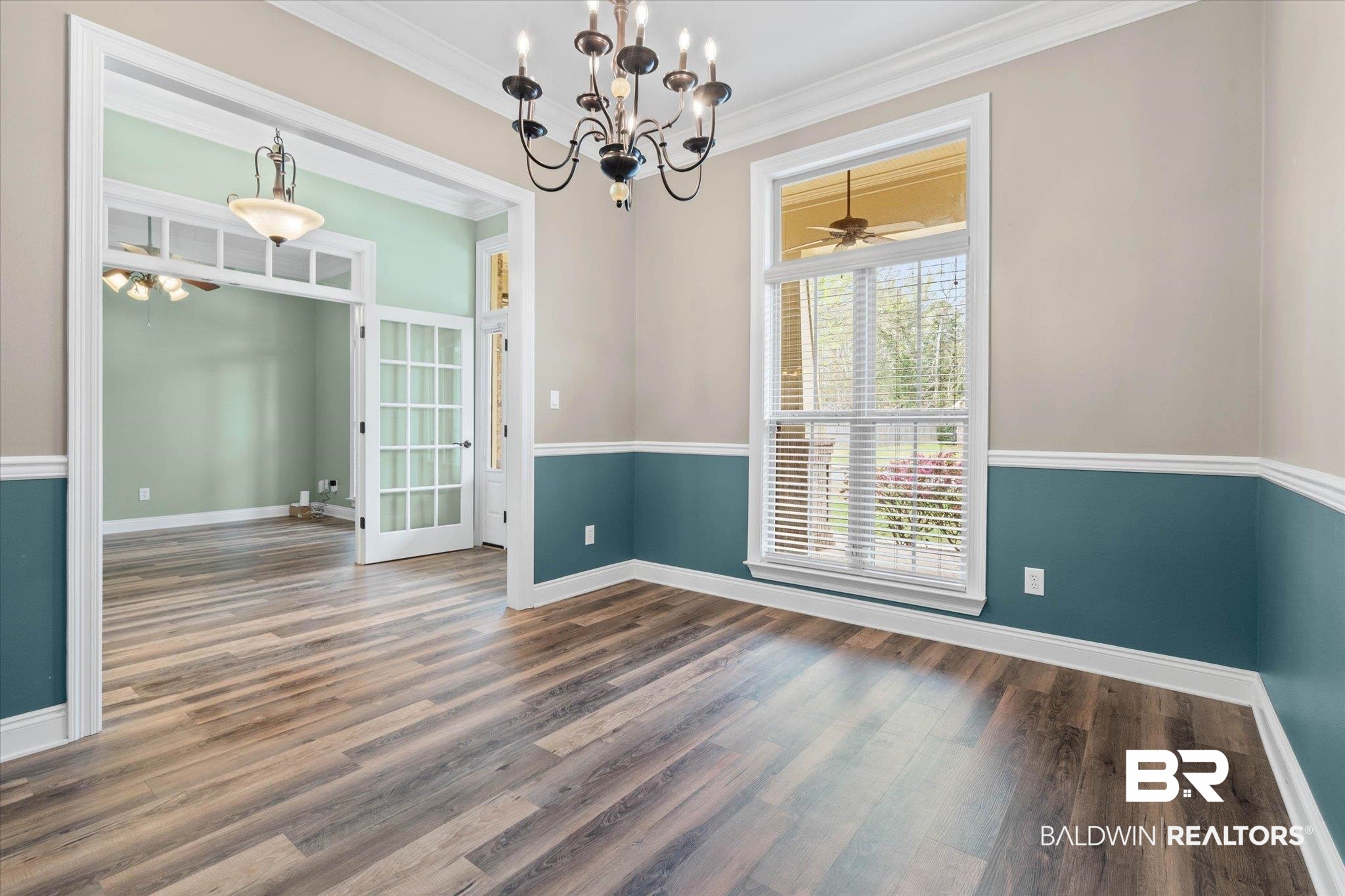 704 Edinburgh Avenue Foley, AL 36535 - Photo 11 of 32 Unfurnished dining area featuring ceiling fan, crown molding, hanging lights, and dark wood-style flooring