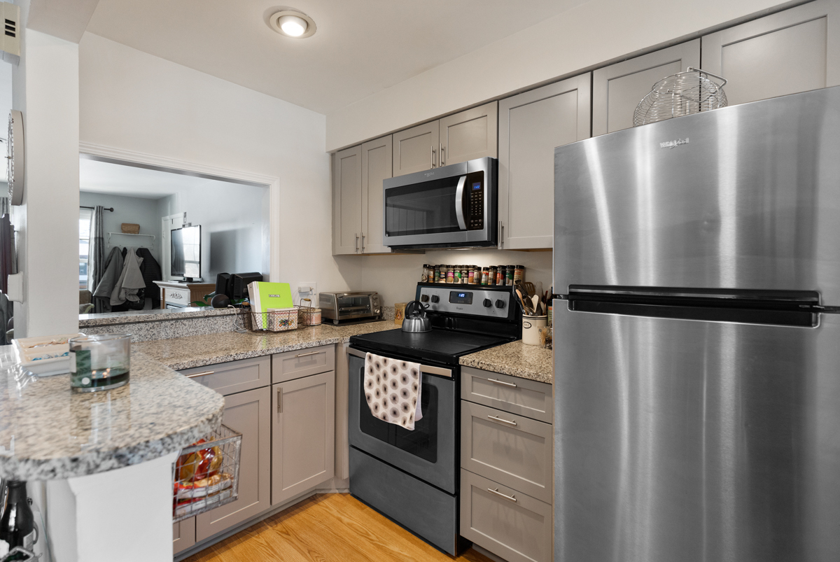 217 Washington Square, Unit D Elk Grove Village, IL 60007 - Photo 6 of 14 a kitchen with stainless steel appliances granite countertop a refrigerator a stove and a sink