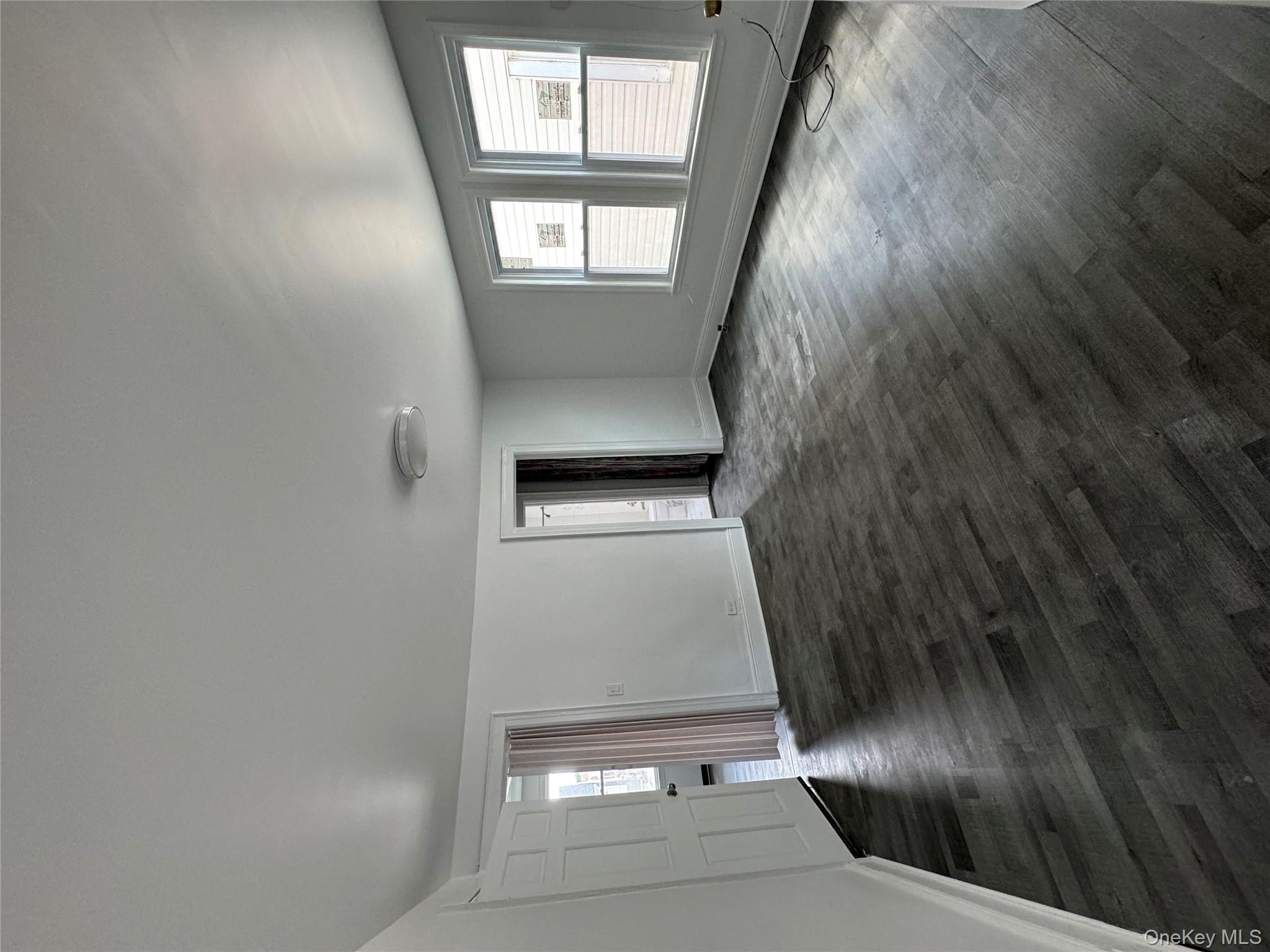 54-13 152nd Street Queens, NY 11355 - Photo 8 of 19 an empty room with wooden floor and windows