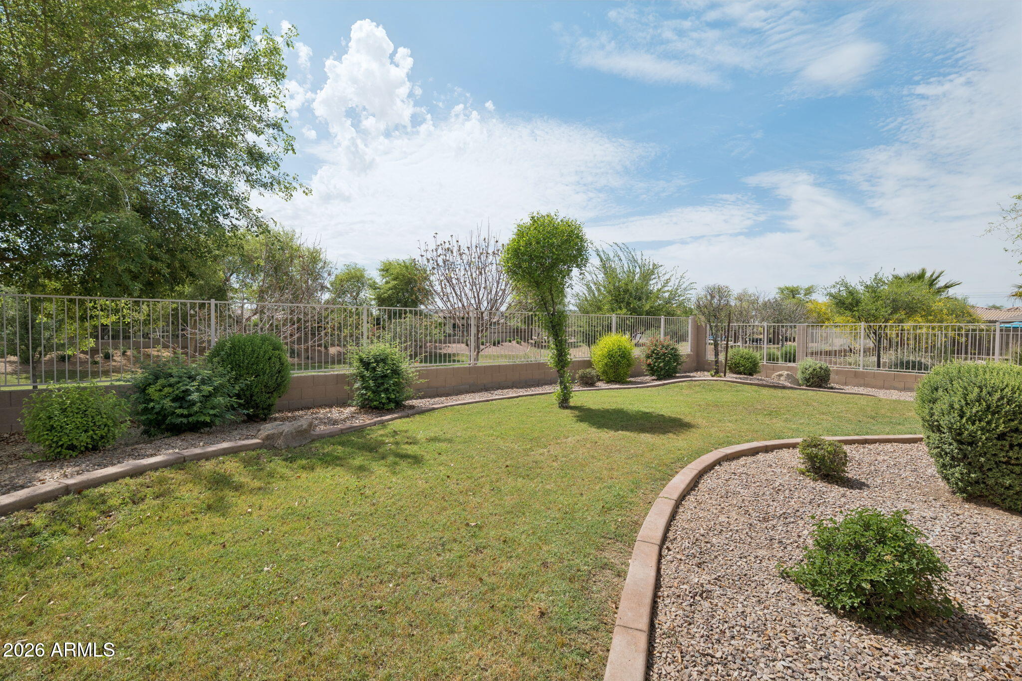 8993 West Ruth Avenue Peoria, AZ 85345 - Photo 22 of 24 a view of a garden with large trees