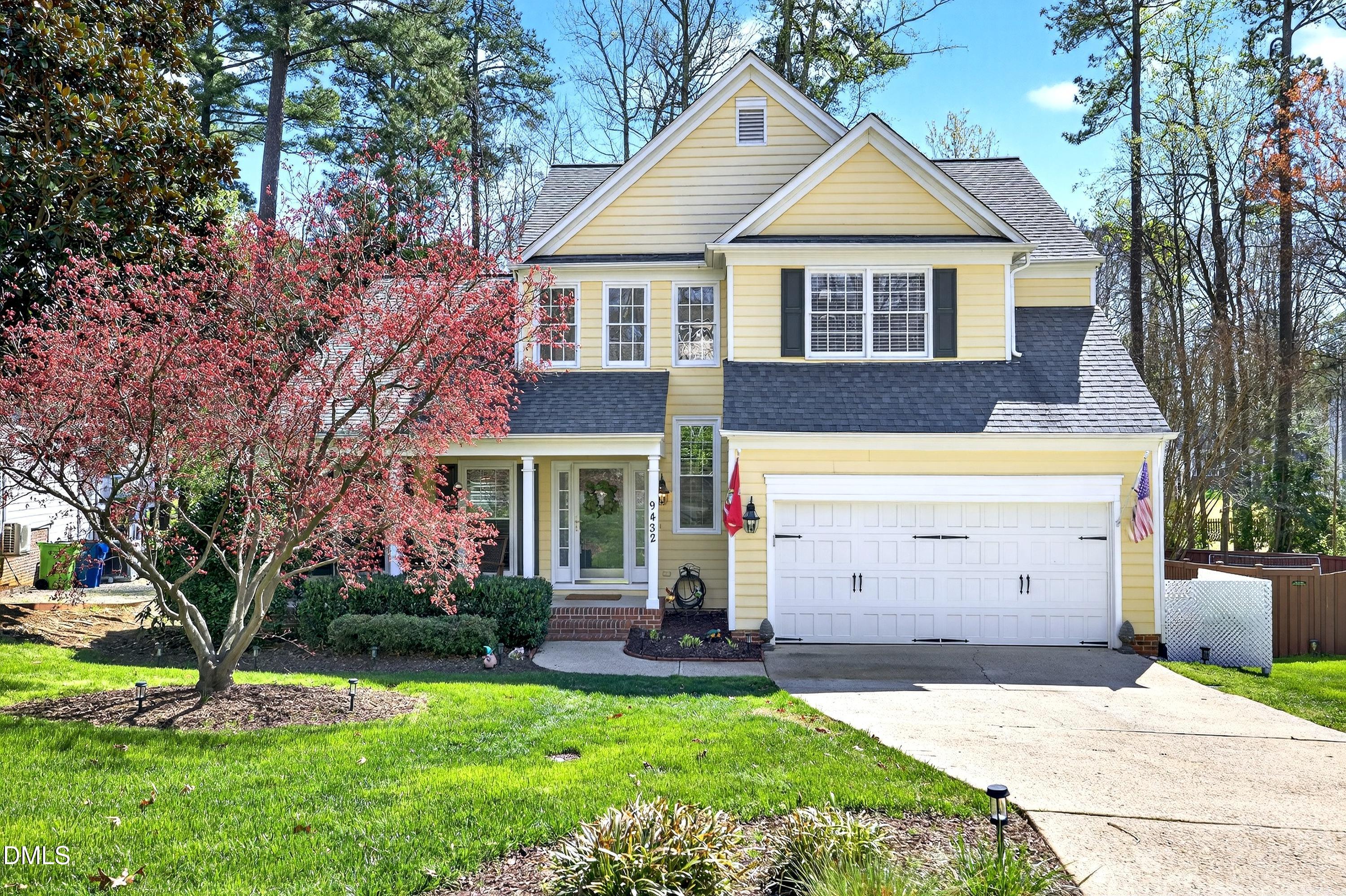 a view of a house with a yard and large tree