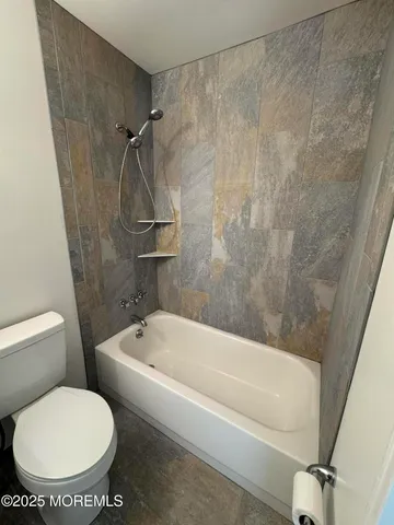 a white toilet sitting next to a bath tub and shower