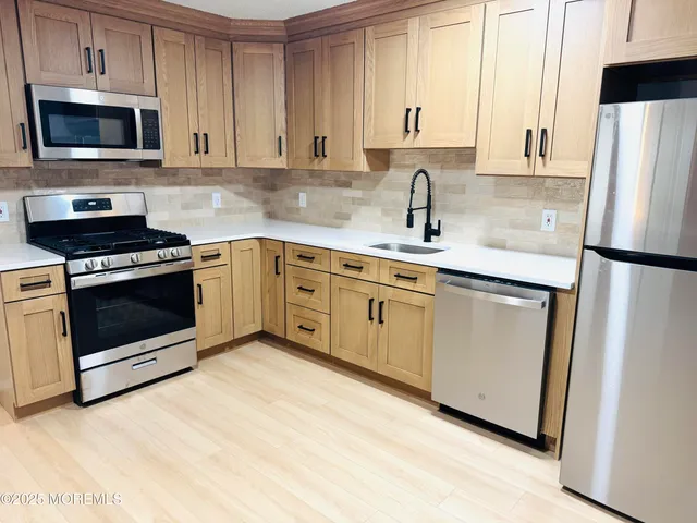 a kitchen with white cabinets sink and stainless steel appliances