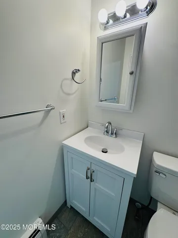 a bathroom with a sink a toilet and mirror