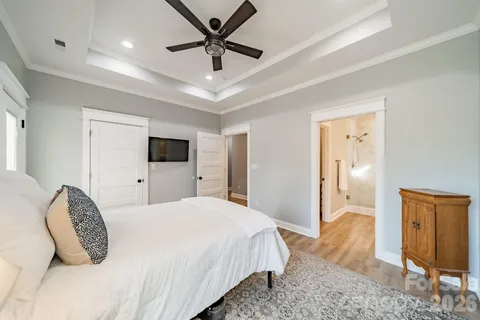 a spacious bedroom with a bed and a flat screen tv