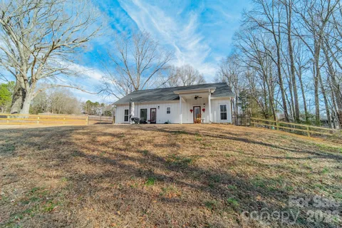 a front view of house with yard and trees around
