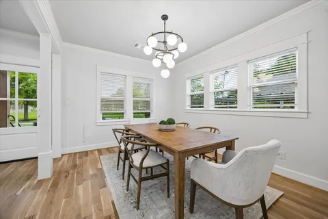 a kitchen with stainless steel appliances granite countertop a refrigerator a sink dishwasher a stove and white cabinets with wooden floor
