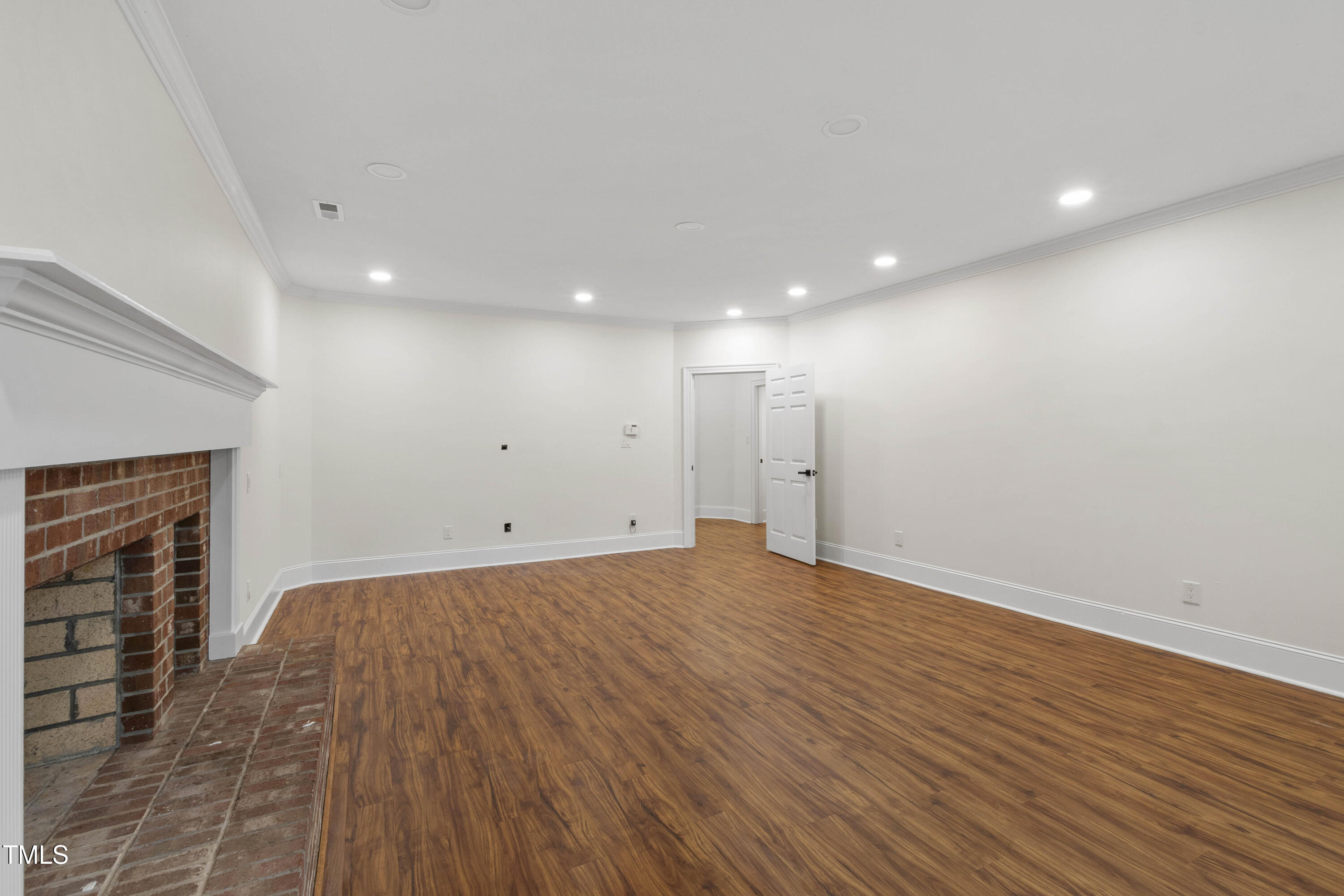 636 Pendleton Lake Road Raleigh, NC 27614 - Photo 25 of 88 a view of an empty room with wooden floor and a fireplace