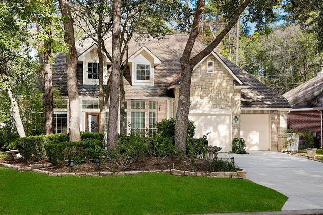 a front view of a house with a yard and potted plants