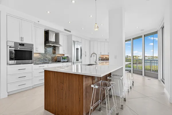 a large kitchen with stainless steel appliances kitchen island granite countertop a large counter top and a stove